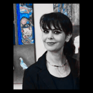 Maysoon black and white pop of color Black and white photo of artist Maysoon Al Gburi with hair pulled back in a pony tail with a toothless smile and bangs.